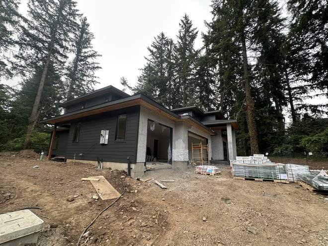 Single level modern custom home with dark siding and deep roof overhangs